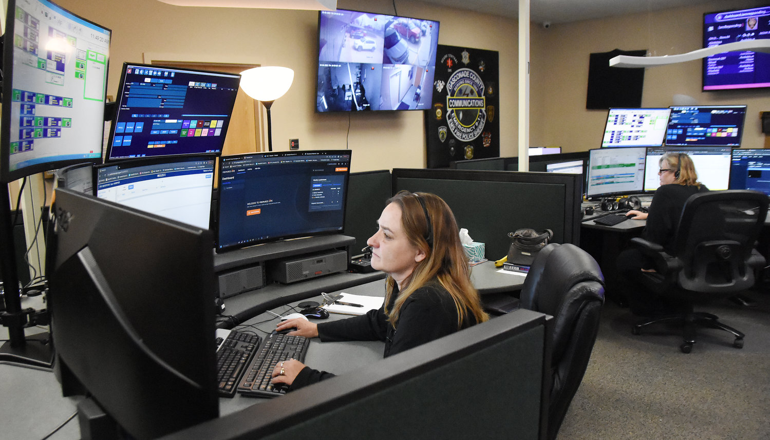 Gasconade E-911 dispatcher Dawn Humphrey (left) handles an out-of-state caller’s request on April 6 for police assistance with a fraud case. Sandy  Lunceford, who handles GIS mapping for the county 911 service, was monitoring the call from her work station.